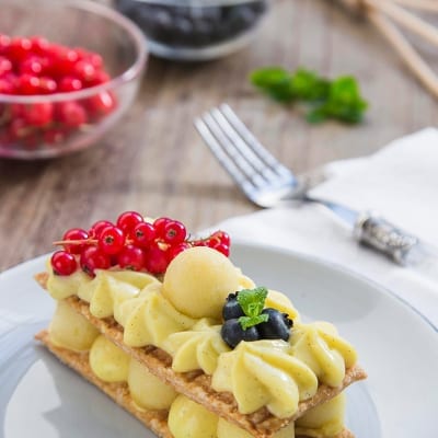 Millefoglie con crema alla vaniglia e mele, guarnito con ribes rosso e mirtilli freschi