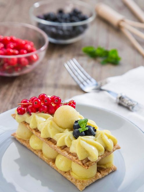 Millefoglie con crema alla vaniglia e mele, guarnito con ribes rosso e mirtilli freschi