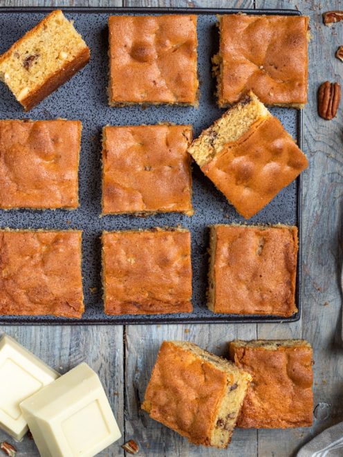 Blondies tagliati a quadrotti su teglia con noci pecan e cioccolato bianco a pezzi