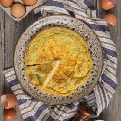 Frittata dorata e soffice, già affettata, con superficie leggermente bruciacchiata