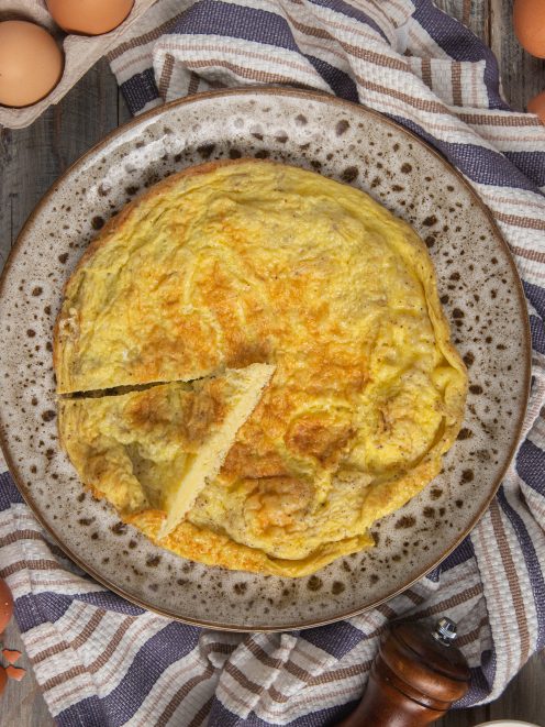 Frittata dorata e soffice, già affettata, con superficie leggermente bruciacchiata