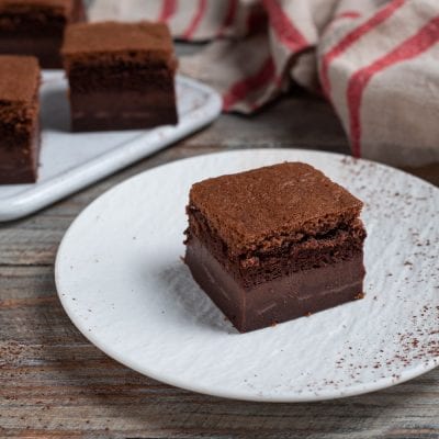 Torta magica al cacao a fette, con lo strato cremoso ben distinto sotto la base spugnosa