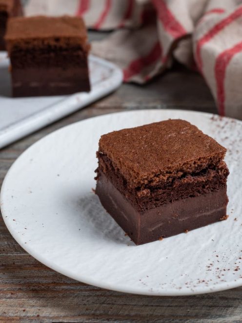 Torta magica al cacao a fette, con lo strato cremoso ben distinto sotto la base spugnosa