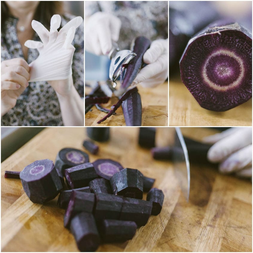 Carote viola pelate con guanti e tagliate a pezzi sul tagliere