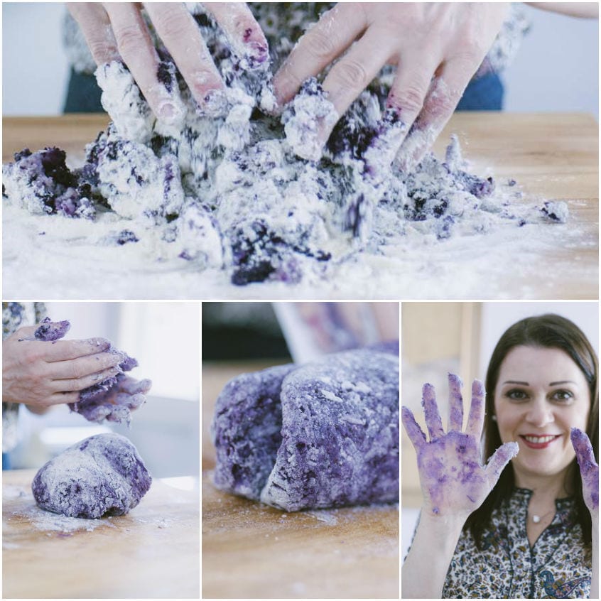 Mani che impastano a mano un composto viola di patate e carote fino a formare un panetto compatto