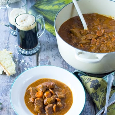 Spezzatino alla Guinness con bocconcini di manzo, carote e sugo scuro servito in piatto fondo