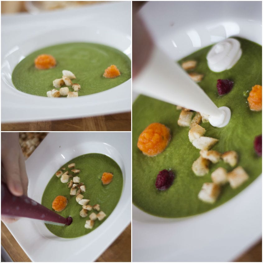 Impiattamento della vellutata verde con crostini, purea di ortaggi e crema al caprino versata a filo
