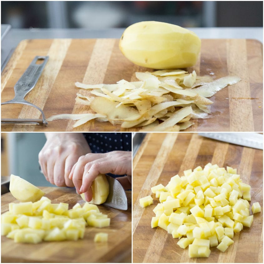 Patate sbucciate e tagliate a cubetti su un tagliere di legno