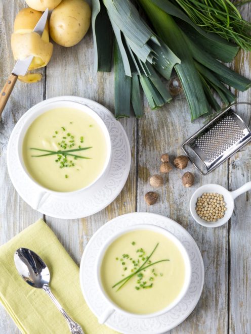 Vichyssoise servita in due ciotole, vellutata di patate e porri guarnita con erba cipollina