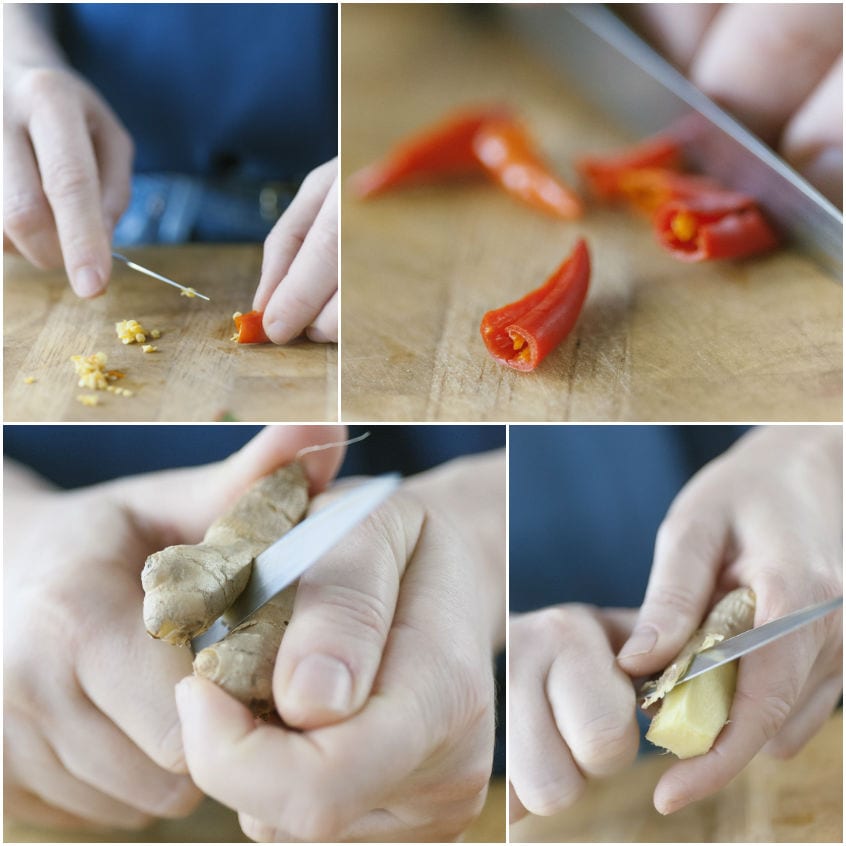 Mani che mondano peperoncino rosso e sbucciano zenzero fresco sul tagliere