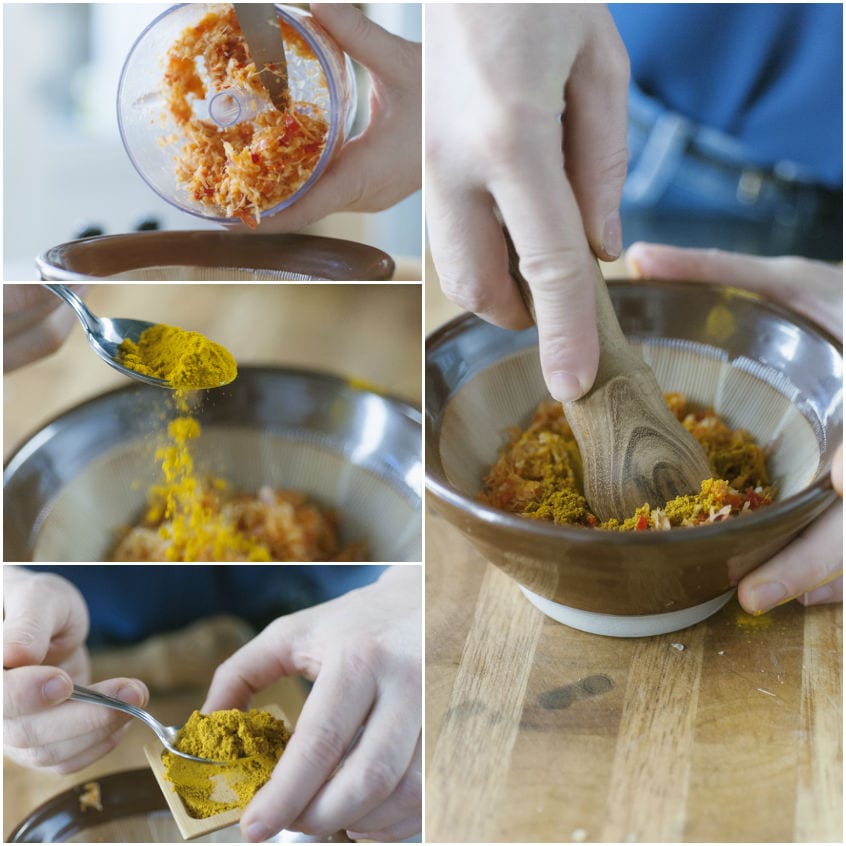 Spezie in polvere, curry e curcuma mescolati nel mortaio con un pestello di legno