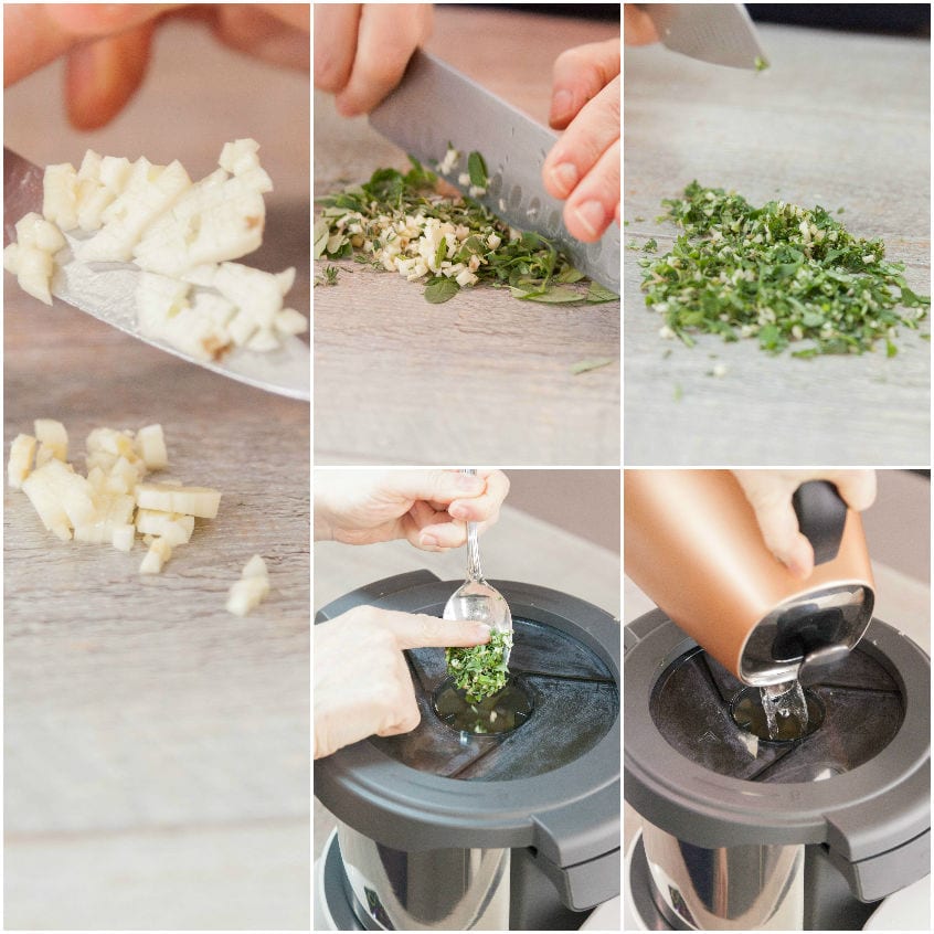 Aglio tritato al coltello, erbe aromatiche sminuzzate e ingredienti versati nel robot da cucina