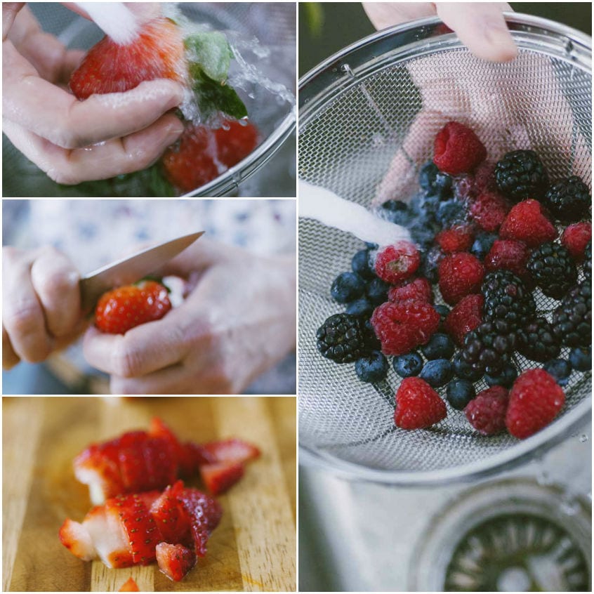 Fragole lavate e tagliate a pezzi, lamponi, mirtilli e more scolati in un colino