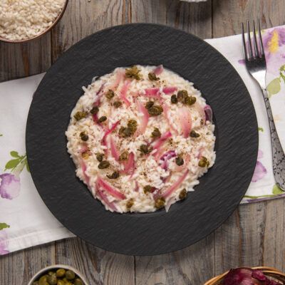 Risotto con capperi e cipolla rossa guarnito con pepe nero macinato