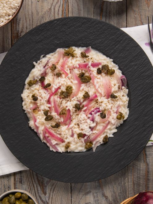Risotto con capperi e cipolla rossa guarnito con pepe nero macinato