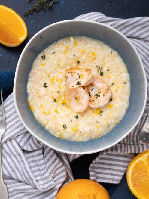 Risotto con gamberi e arancia guarnito con scorza grattugiata e timo fresco