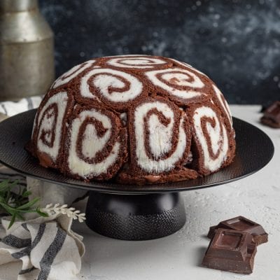 Zuccotto swiss roll a forma di cupola, rivestito di rotolini al cacao con spirale bianca e crema