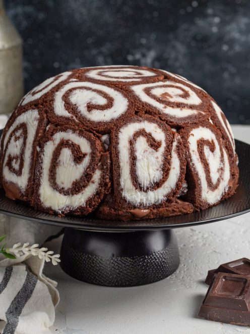 Zuccotto swiss roll a forma di cupola, rivestito di rotolini al cacao con spirale bianca e crema