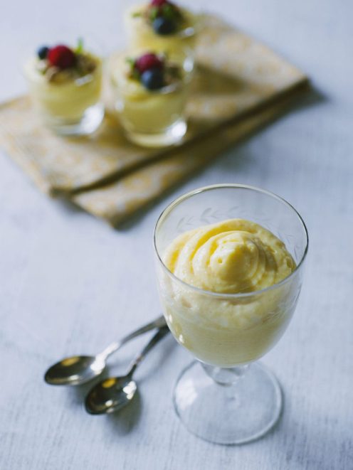 Crema chiboust servita in calici con ciuffo a spirale, guarnita con frutti di bosco freschi