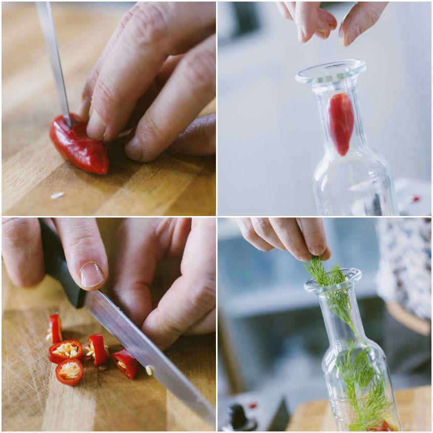 Peperoncino tagliato a rondelle e aneto inseriti in una bottiglietta per olio aromatizzato