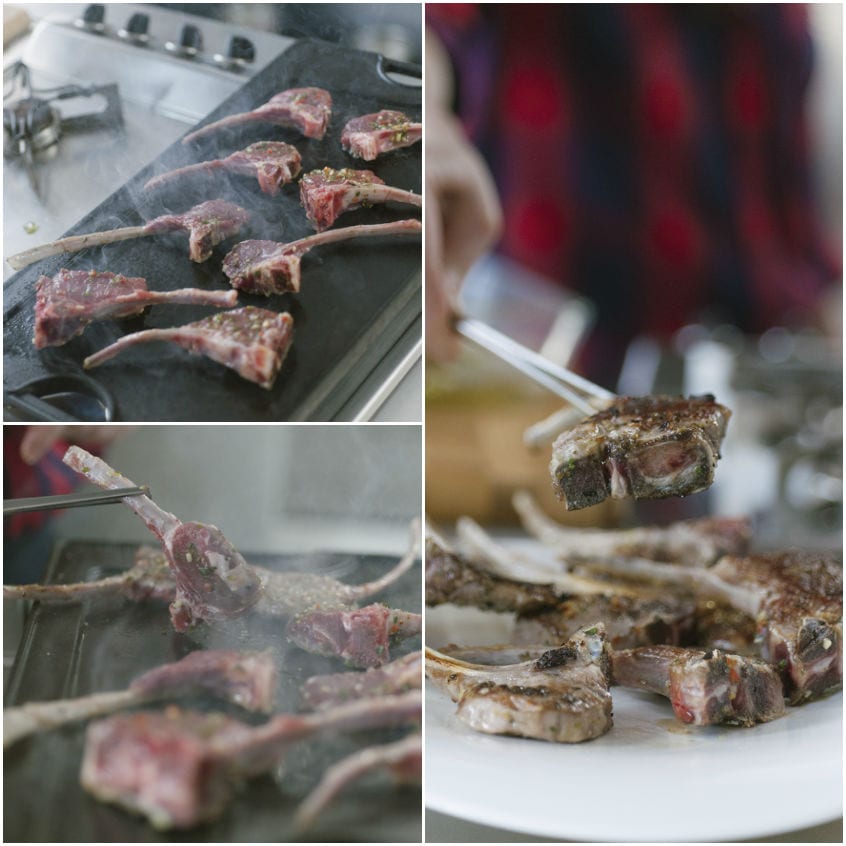 Costolette d'agnello sulla piastra fumante, girate con le pinze durante la cottura