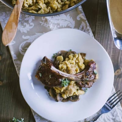 Spätzle con costolette d'agnello e funghi, guarniti con timo fresco