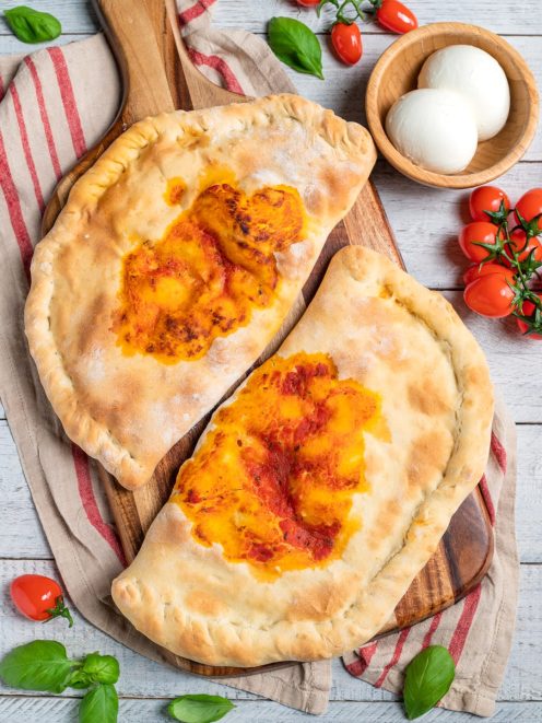 Calzone al forno con sugo di pomodoro e formaggio filante, appena sfornato