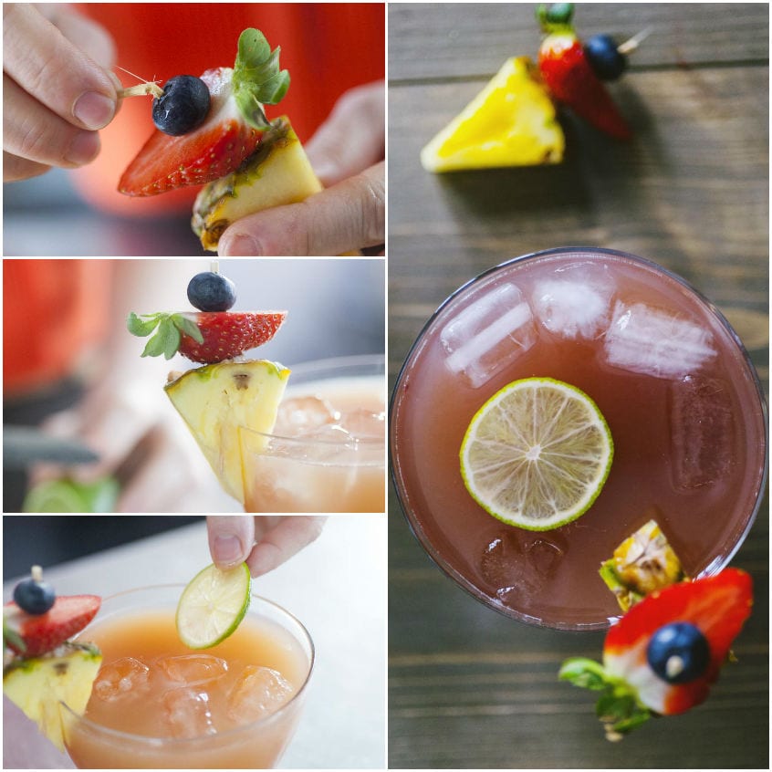 Spiedino di frutta con ananas, fragola e mirtillo posizionato sul bordo del bicchiere con fettina di lime