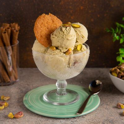 Gelato al pistacchio in coppa con granella di pistacchi e un biscotto croccante
