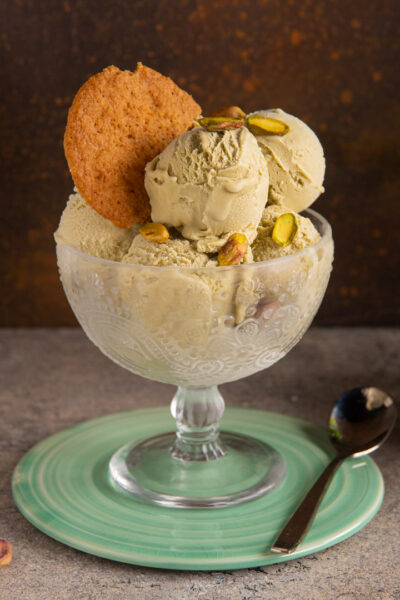 Gelato al pistacchio in coppa con granella di pistacchi e un biscotto croccante