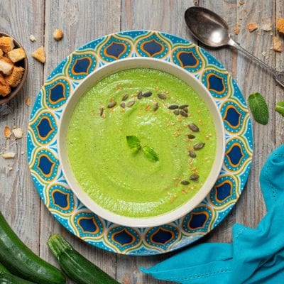 Crema di zucchine e menta guarnita con semi di zucca, sesamo e foglioline fresche