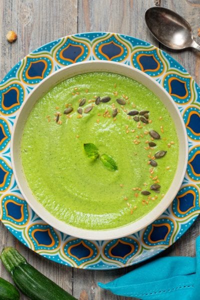 Crema di zucchine e menta guarnita con semi di zucca, sesamo e foglioline fresche