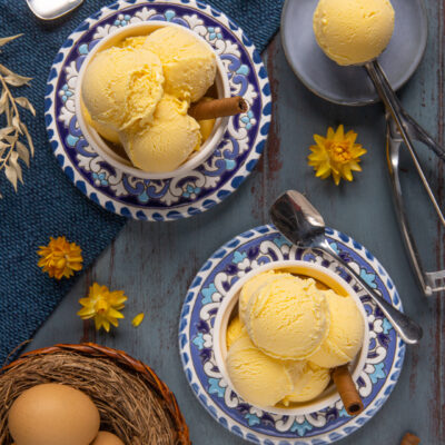 Gelato alla crema servito a palline con una stecca di cannella