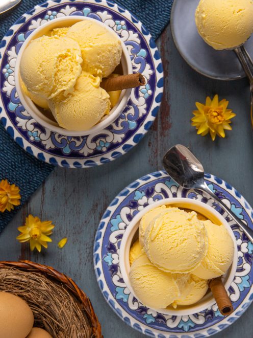 Gelato alla crema servito a palline con una stecca di cannella