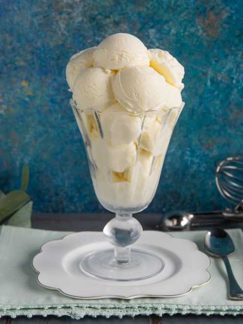 Gelato allo yogurt servito in coppa con tante palline cremose impilate in alto
