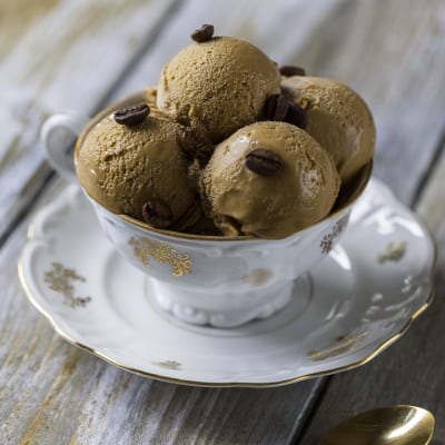 Gelato al caffè servito in tre palline con chicchi di caffè interi in superficie