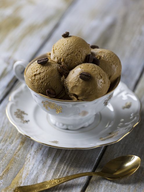 Gelato al caffè servito in tre palline con chicchi di caffè interi in superficie