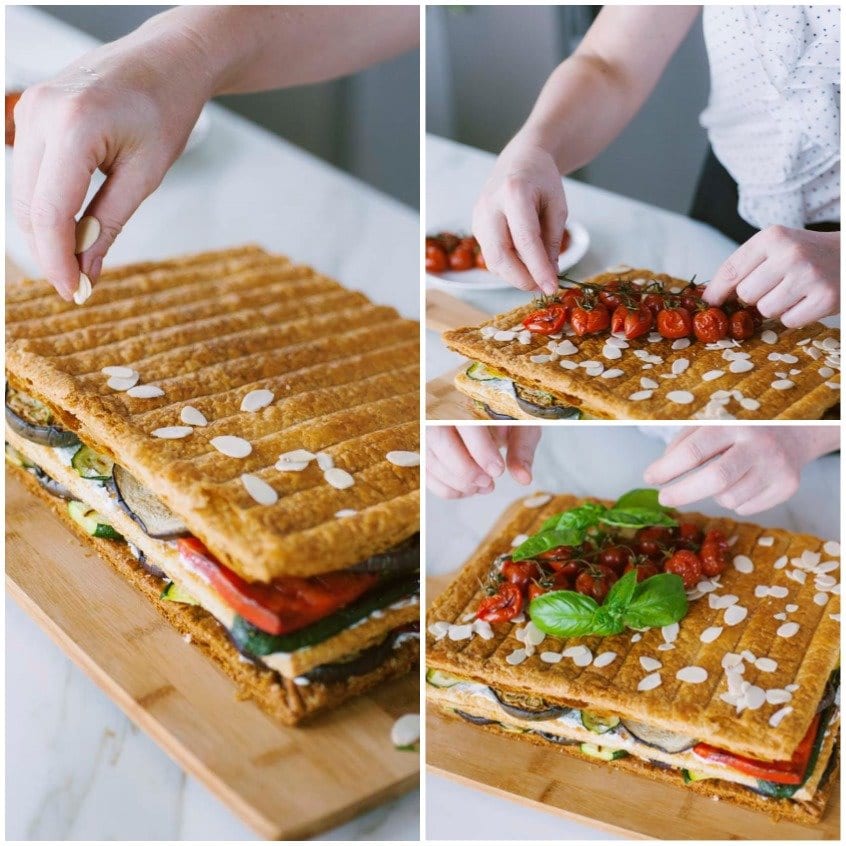 Mani che guarniscono la millefoglie di verdure con mandorle, pomodorini confit e basilico fresco