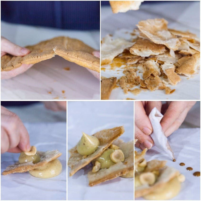 Mani che spezzano la sfoglia e assemblano la millefoglie scomposta con crema, uva e nocciole