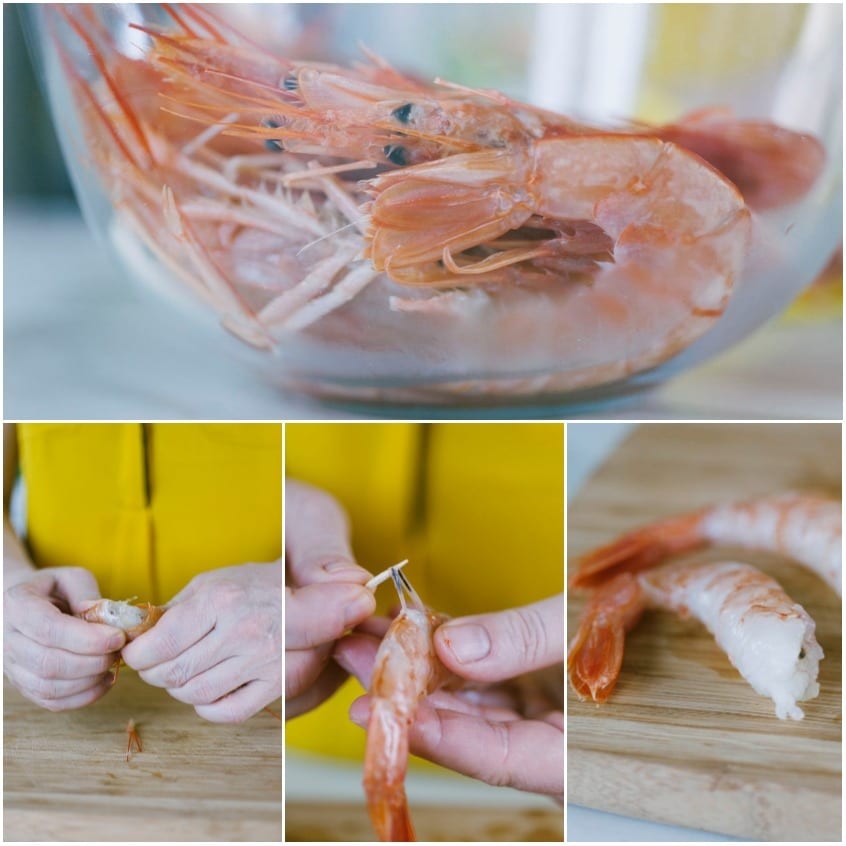 Mani che sgusciano i gamberi lasciando la coda intatta sul tagliere