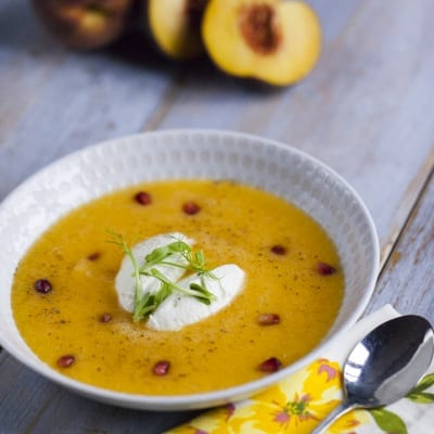 Gazpacho di melone, pesca e feta con quenelle di formaggio, chicchi di melograno e germogli freschi