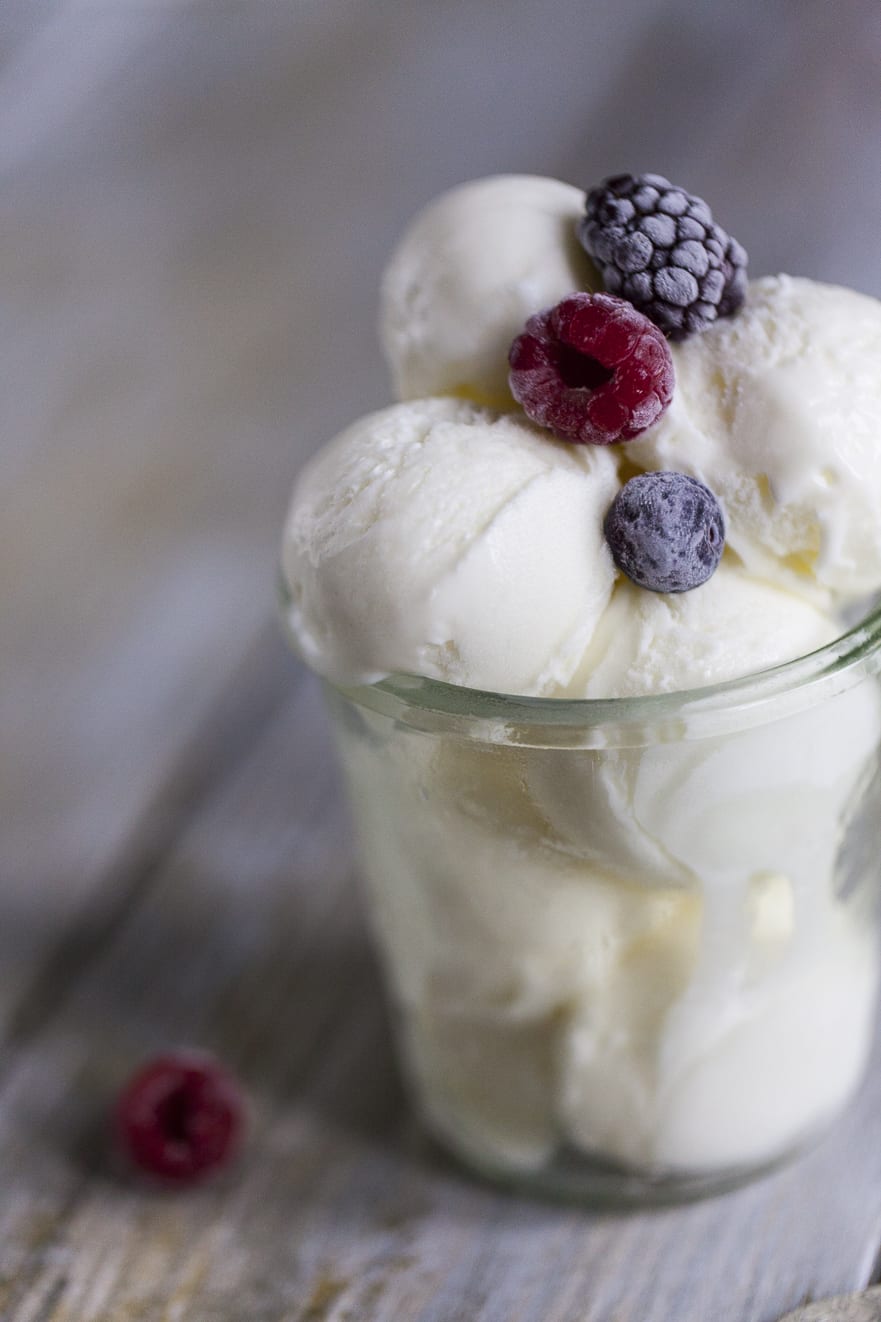 Palline di gelato al cocco guarnite con frutti di bosco surgelati