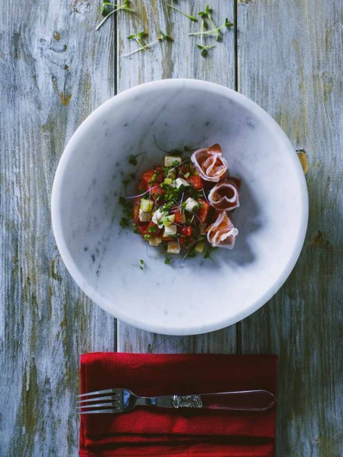 Insalata di anguria, feta e cetrioli con rose di prosciutto crudo e germogli freschi