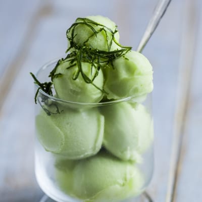 Sorbetto al cetriolo servito a palline con guarnizione di foglie di menta sfilacciate