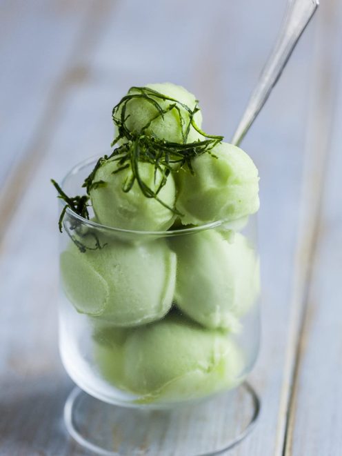 Sorbetto al cetriolo servito a palline con guarnizione di foglie di menta sfilacciate