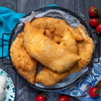 Calzone fritto dorato e croccante servito su carta da forno