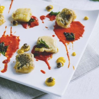 Baccalà fritto in pastella di farina di ceci con salsa di peperoni, capperi e foglie di prezzemolo