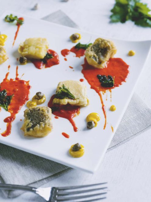 Baccalà fritto in pastella di farina di ceci con salsa di peperoni, capperi e foglie di prezzemolo