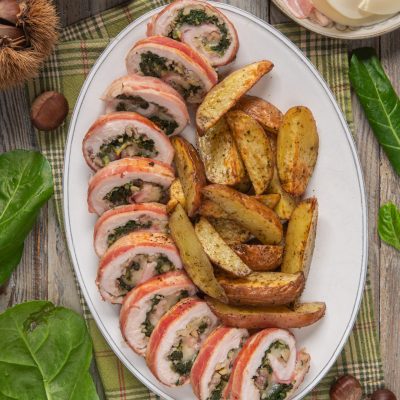 Rollè di pollo con castagne e bacon affettato, con ripieno di spinaci e castagne, servito con patate al forno