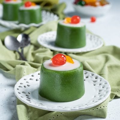 Tortino dolce alla cassata con involucro verde, glassa bianca e ciliegia candita in cima